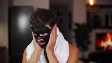 Genç adam banyoya yüz maskesi takıyor..