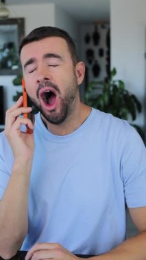 Kapalı alanda cep telefonuyla konuşan adam.