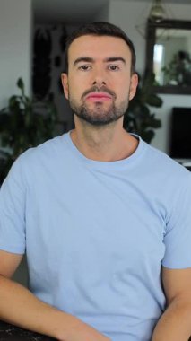 Evde el kol hareketi yapan yakışıklı bir adamın portresi.