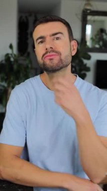 Evde el kol hareketi yapan yakışıklı bir adamın portresi.