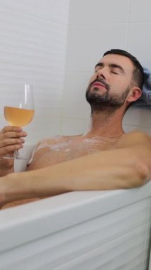 İnsan portresi banyo küvetinde dinlenirken içkinin keyfini çıkarıyor..