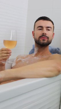 İnsan portresi banyo küvetinde dinlenirken içkinin keyfini çıkarıyor..