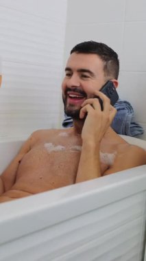 Adam telefonda konuşurken küvette dinleniyor..