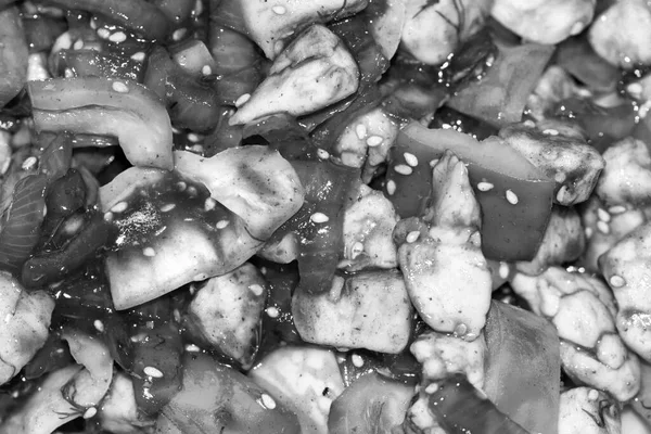 Kuře s cibulí, sladkým pepřem a sezamovými semínky v tmavé omáčce. Černobílá fotografie. — Stock fotografie