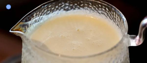 Leche hervida en un frasco de vidrio con asa y boquilla —  Fotos de Stock