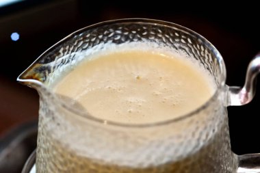 Cam bir kavanozda kaynamış süt, sapı ve borusu var.