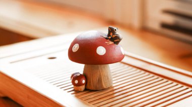 Küçük bir kurbağa sineğin üzerinde oturuyor. Kil çay biblosu, çaydanlık. 