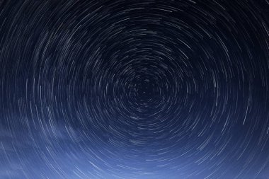 Yıldızsal izler, parlak yıldızların gece mavi gökyüzüne karşı Kutup Yıldızı etrafında dönüşleri.
