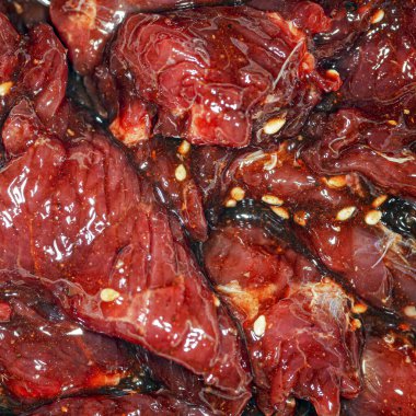 Parlak, sulu, baharatlı, yağlı ve susamlı et dilimleri.