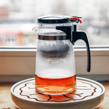 Çay demlerken düğmeli ve mataralı plastik cam çaydanlık.