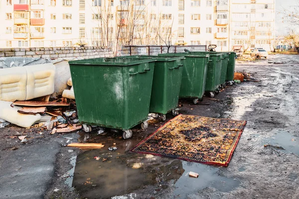 Conserve de gunoi într-o curte provincială rusă și un covor șic în fața lor zăcut într-o baltă — Fotografie, imagine de stoc