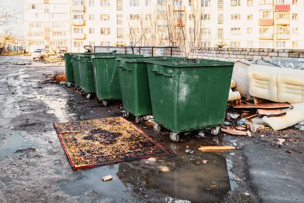 Conserve de gunoi într-o curte provincială rusă și un covor șic în fața lor zăcut într-o baltă — Fotografie, imagine de stoc