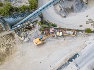 Kaya ve kum madenciliği için endüstriyel çukurdaki çöp kamyonunun hava manzarası..