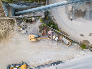 Kaya ve kum madenciliği için endüstriyel çukurdaki çöp kamyonunun hava manzarası..