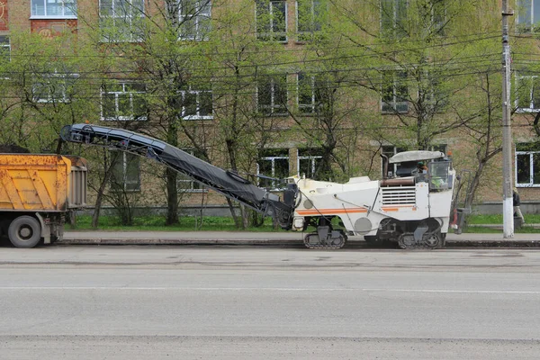 ロシアの街の通りにアスファルトを敷設するための特別な道路設備 春の道路補修工事 — ストック写真