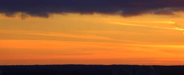 Sun below the horizon and clouds in the fiery dramatic orange sky at sunset or dawn backlit by the sun. Place for text and design.