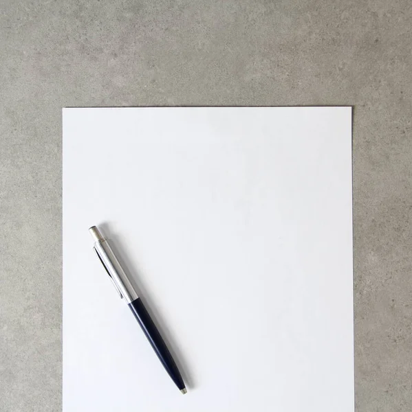 Modelo Papel Branco Com Uma Caneta Esferográfica Sobre Fundo Concreto — Fotografia de Stock