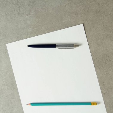 Tükenmez kalemle beyaz kağıt şablonu ve açık gri beton arka planda basit bir kalem. Yeni fikir, iş planı ve strateji kavramı, içeriğin geliştirilmesi ve uygulanması. Metin için boş alanı olan stok fotoğrafı.