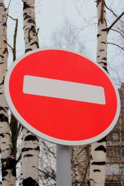 Beyaz çizgili kırmızı yol işareti parlak gökyüzüne ve ağaçlara karşı hareket yasaklıyor. Girmeyin. İçki yasağı konsepti, çıkmaz sokak, umutsuzluk ve dur..