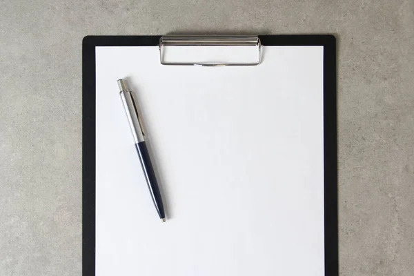 Beyaz kağıt şablonu açık gri arka plan üzerinde tükenmez kalemle siyah bir tablet içinde şarjörlü. Yeni fikir, iş planı ve strateji kavramı, içeriğin geliştirilmesi ve uygulanması. Metin için boş alanı olan stok fotoğrafı.