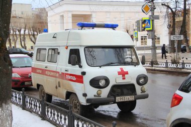 13-11-2020. Rusya, Syktyvkar. Rusya 'da bir şehir caddesinde mavi ışıklı kırmızı çizgili beyaz eski Rus ambulans markası UAZ.