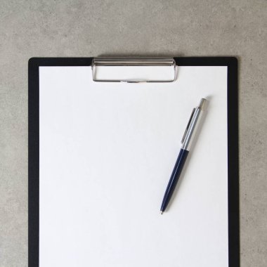 Beyaz kağıt şablonu açık gri arka plan üzerinde tükenmez kalemle siyah bir tablet içinde şarjörlü. Yeni fikir, iş planı ve strateji kavramı, içeriğin geliştirilmesi ve uygulanması. Metin için boş alanı olan stok fotoğrafı.