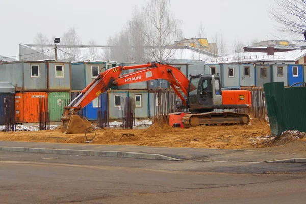 2020年11月15日 ロシア Syktyvkar 大規模なオレンジ掘削機建築主の仮設住宅を背景に 砂の上に建設現場に立ち並ぶ広い鉄軌道上の立ち姿 — ストック写真