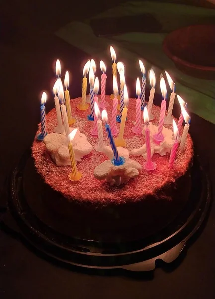 Koyu arkaplanda mumlar olan doğum günü pastası. Doğum günü kutlaması konsepti, ev partisi. Web ve baskı, arkaplan ve duvar kağıdı için stok fotoğrafı. 