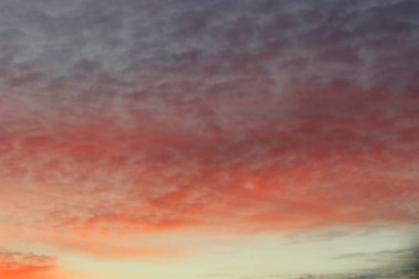 Ufkun altında güneş ve gün batımında veya şafakta güneşin aydınlattığı ateşli turuncu gökyüzünde bulutlar. Metin ve tasarım için yer.