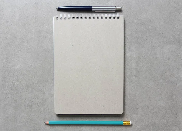 一个春天的笔记本与一张手工纸A5与圆珠笔和简单的绿色石墨铅笔在轻灰色混凝土背景 新概念 业务计划和战略 内容的开发和实施 空白的文字空间 — 图库照片