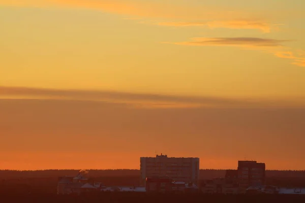 Sun below the horizon and clouds in the fiery dramatic orange sky at sunset or dawn backlit by the sun. Place for text and design.