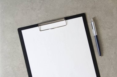 Beyaz kağıt şablonu açık gri arka plan üzerinde tükenmez kalemle siyah bir tablet içinde şarjörlü. Yeni fikir, iş planı ve strateji kavramı, içeriğin geliştirilmesi ve uygulanması. Metin için boş alanı olan stok fotoğrafı.