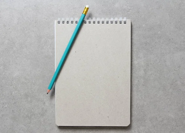 一个春天笔记本与一张工艺纸A5与简单的绿色石墨铅笔在浅灰混凝土背景 新概念 业务计划和战略 内容的开发和实施 空白的文字空间 — 图库照片