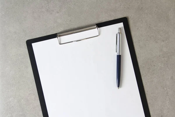 Beyaz kağıt şablonu açık gri arka plan üzerinde tükenmez kalemle siyah bir tablet içinde şarjörlü. Yeni fikir, iş planı ve strateji kavramı, içeriğin geliştirilmesi ve uygulanması. Metin için boş alanı olan stok fotoğrafı.
