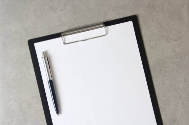 Beyaz kağıt şablonu açık gri arka plan üzerinde tükenmez kalemle siyah bir tablet içinde şarjörlü. Yeni fikir, iş planı ve strateji kavramı, içeriğin geliştirilmesi ve uygulanması. Metin için boş alanı olan stok fotoğrafı.