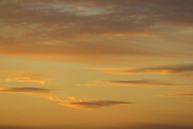 Ufkun altında güneş ve gün batımında veya şafakta güneşin aydınlattığı ateşli turuncu gökyüzünde bulutlar. Metin ve tasarım için yer.