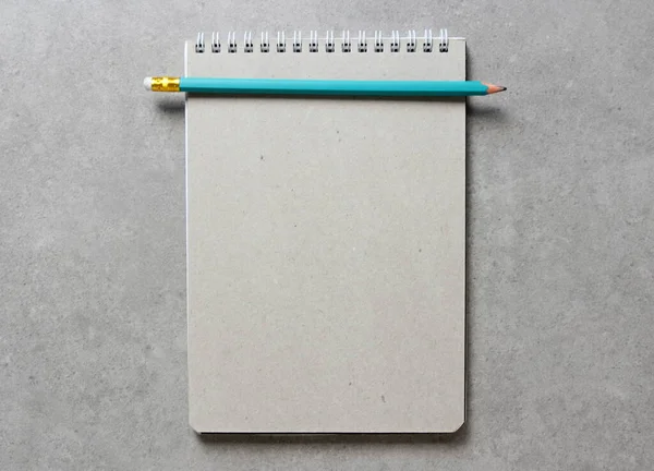 一个春天笔记本与一张工艺纸A5与简单的绿色石墨铅笔在浅灰混凝土背景 新概念 业务计划和战略 内容的开发和实施 空白的文字空间 — 图库照片