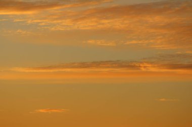 Ufkun altında güneş ve gün batımında veya şafakta güneşin aydınlattığı ateşli turuncu gökyüzünde bulutlar. Metin ve tasarım için yer.