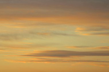 Ufkun altında güneş ve gün batımında veya şafakta güneşin aydınlattığı ateşli turuncu gökyüzünde bulutlar. Metin ve tasarım için yer.