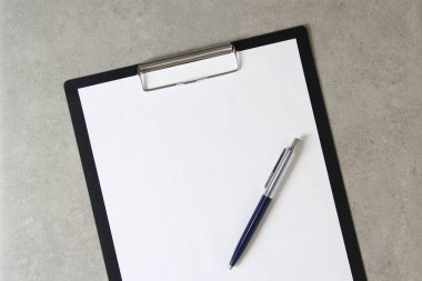 Beyaz kağıt şablonu açık gri arka plan üzerinde tükenmez kalemle siyah bir tablet içinde şarjörlü. Yeni fikir, iş planı ve strateji kavramı, içeriğin geliştirilmesi ve uygulanması