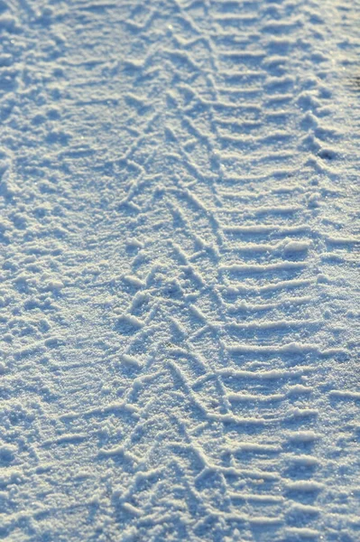 Шиномонтажні колії, залишені на снігу в яскравий сонячний день — стокове фото