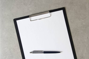 Beyaz kağıt şablonu açık gri arka plan üzerinde tükenmez kalemle siyah bir tablet içinde şarjörlü. Yeni fikir, iş planı ve strateji kavramı, içeriğin geliştirilmesi ve uygulanması. Metin için boş alanı olan stok fotoğrafı.