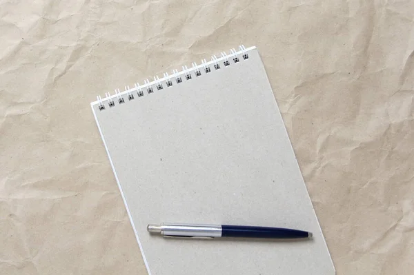 Notepad Gri Arc Alb Încolăcit Stilou Fundal Hârtie Ambarcațiuni Bej — Fotografie, imagine de stoc