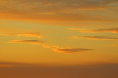 Ufkun altında güneş ve gün batımında veya şafakta güneşin aydınlattığı ateşli turuncu gökyüzünde bulutlar. Metin ve tasarım için yer.