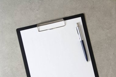 Beyaz kağıt şablonu açık gri arka plan üzerinde tükenmez kalemle siyah bir tablet içinde şarjörlü. Yeni fikir, iş planı ve strateji kavramı, içeriğin geliştirilmesi ve uygulanması. Metin için boş alanı olan stok fotoğrafı.