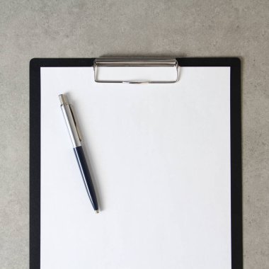 Beyaz kağıt şablonu açık gri arka plan üzerinde tükenmez kalemle siyah bir tablet içinde şarjörlü. Yeni fikir, iş planı ve strateji kavramı, içeriğin geliştirilmesi ve uygulanması. Metin için boş alanı olan stok fotoğrafı.