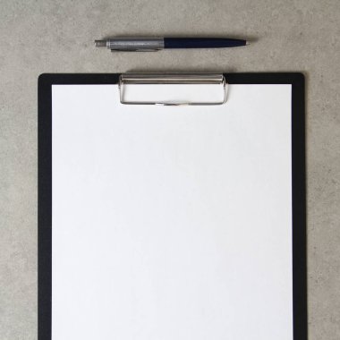 Beyaz kağıt şablonu açık gri arka plan üzerinde tükenmez kalemle siyah bir tablet içinde şarjörlü. Yeni fikir, iş planı ve strateji kavramı, içeriğin geliştirilmesi ve uygulanması. Metin için boş alanı olan stok fotoğrafı.