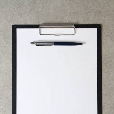 Beyaz kağıt şablonu açık gri arka plan üzerinde tükenmez kalemle siyah bir tablet içinde şarjörlü. Yeni fikir, iş planı ve strateji kavramı, içeriğin geliştirilmesi ve uygulanması. Metin için boş alanı olan stok fotoğrafı.