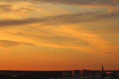 Ufkun altında güneş ve gün batımında veya şafakta güneşin aydınlattığı ateşli turuncu gökyüzünde bulutlar. Metin ve tasarım için yer.