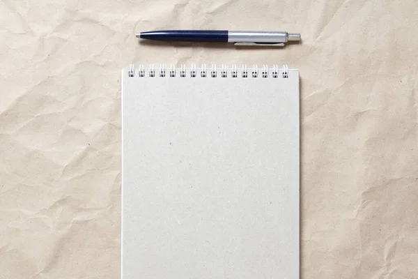 Szary Notatnik Białą Zwiniętą Sprężyną Długopisem Tle Beżowego Pogniecionego Papieru — Zdjęcie stockowe